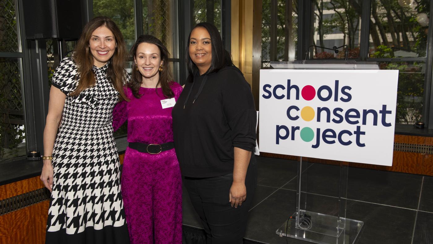Ewa Abrams, Kate Parker and Arlan Hamilton stand next to a Schools Consent Project sign